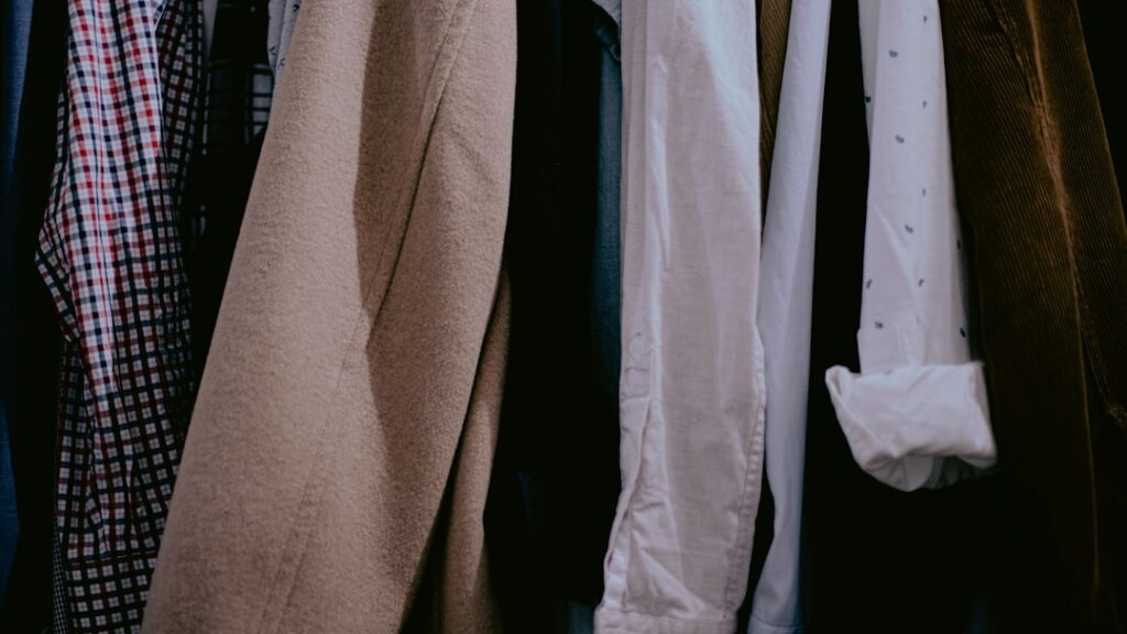 Flat-lay of a capsule wardrobe for men with versatile essentials in navy, charcoal, stone, and white